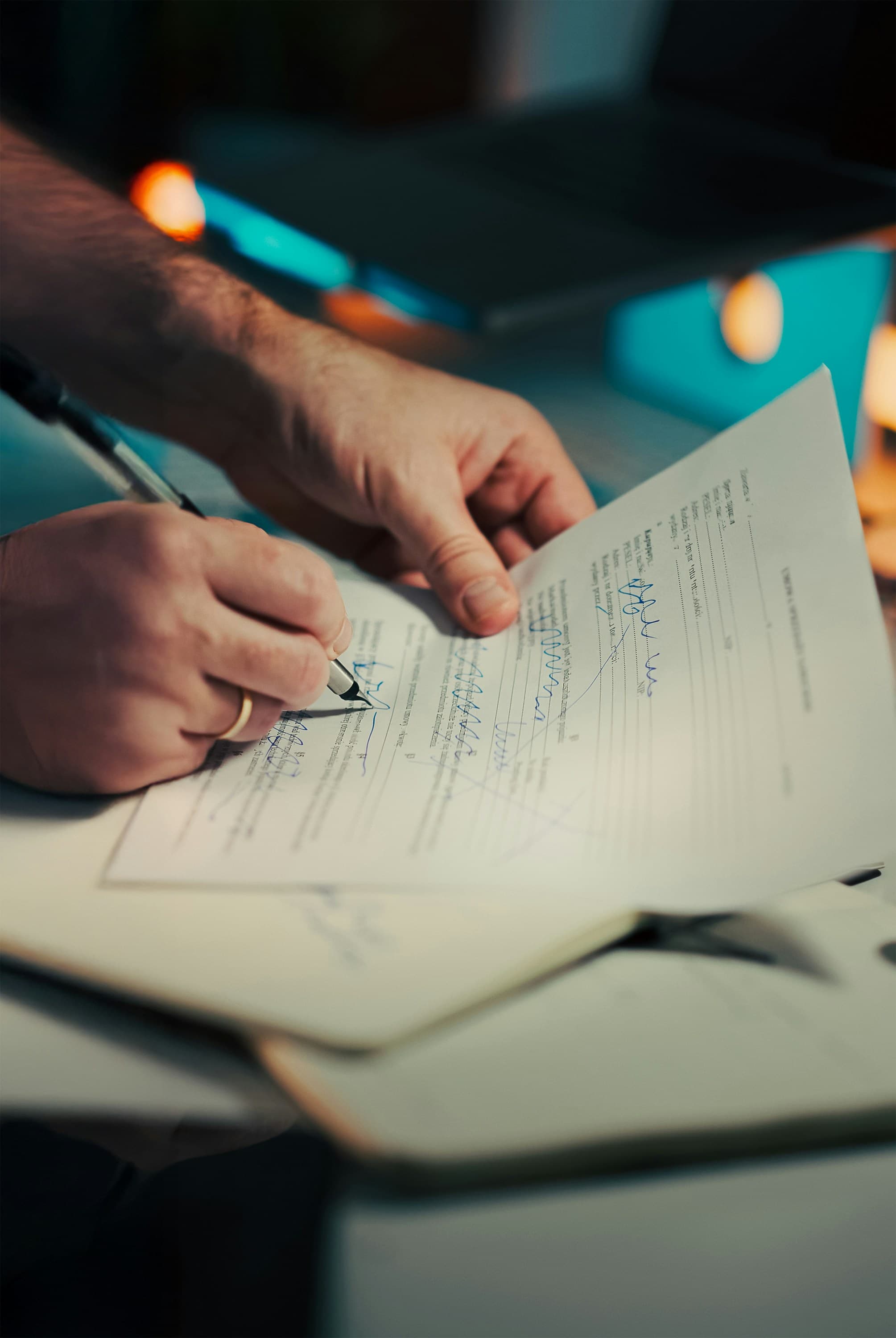 Person signing an official document with a pen